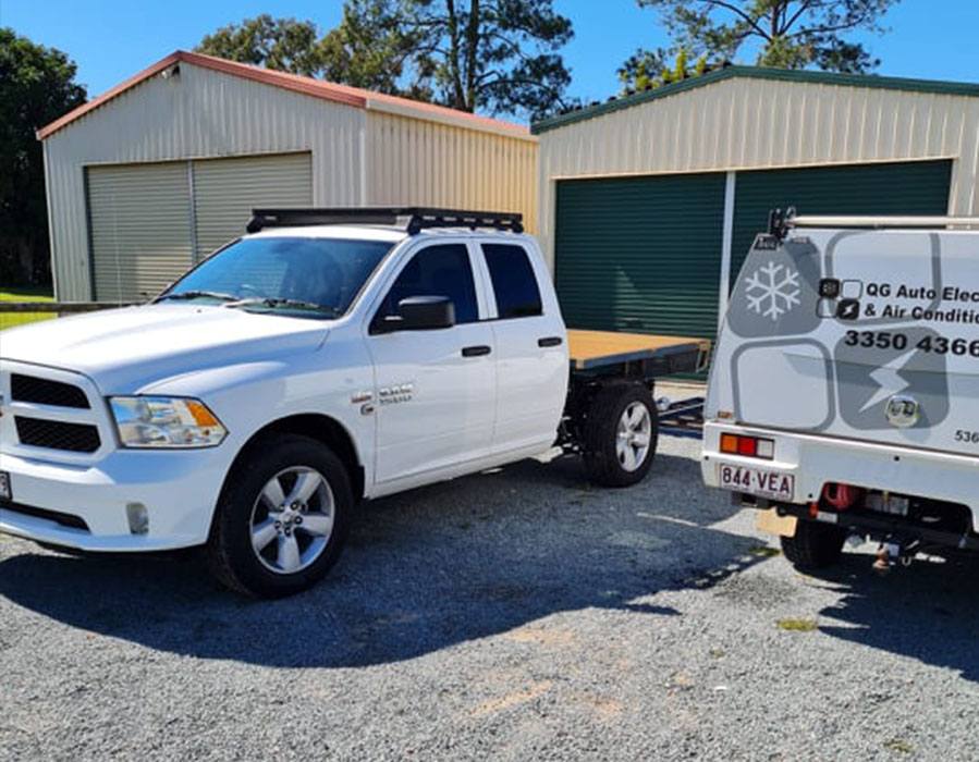 QG Auto's White Dodge Ram 1500 parked in a driveway in Brisbane alongside a QG Auto Electrical van.